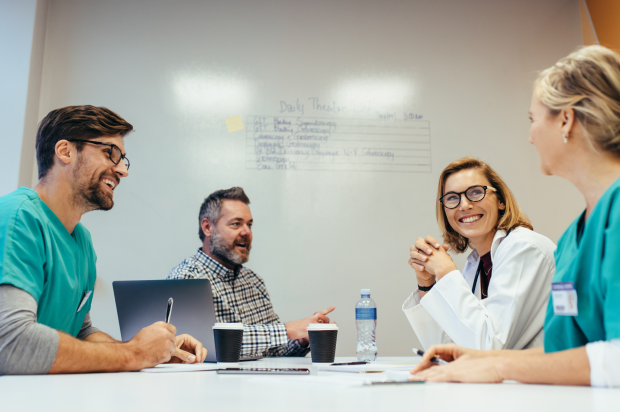 Group of smiling health care industry coworkers in a meeting room
