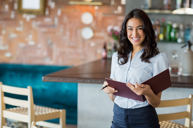 Smiling female restaurant manager holding a notebook