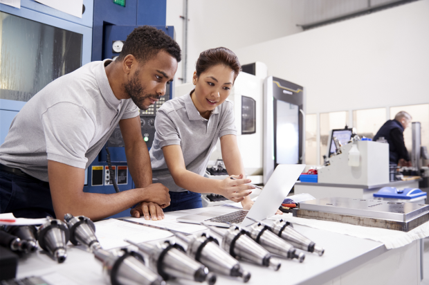 Manufacturing coworkers reviewing something on a laptop together