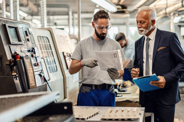 Boss and manufacturing worker reviewing a document together